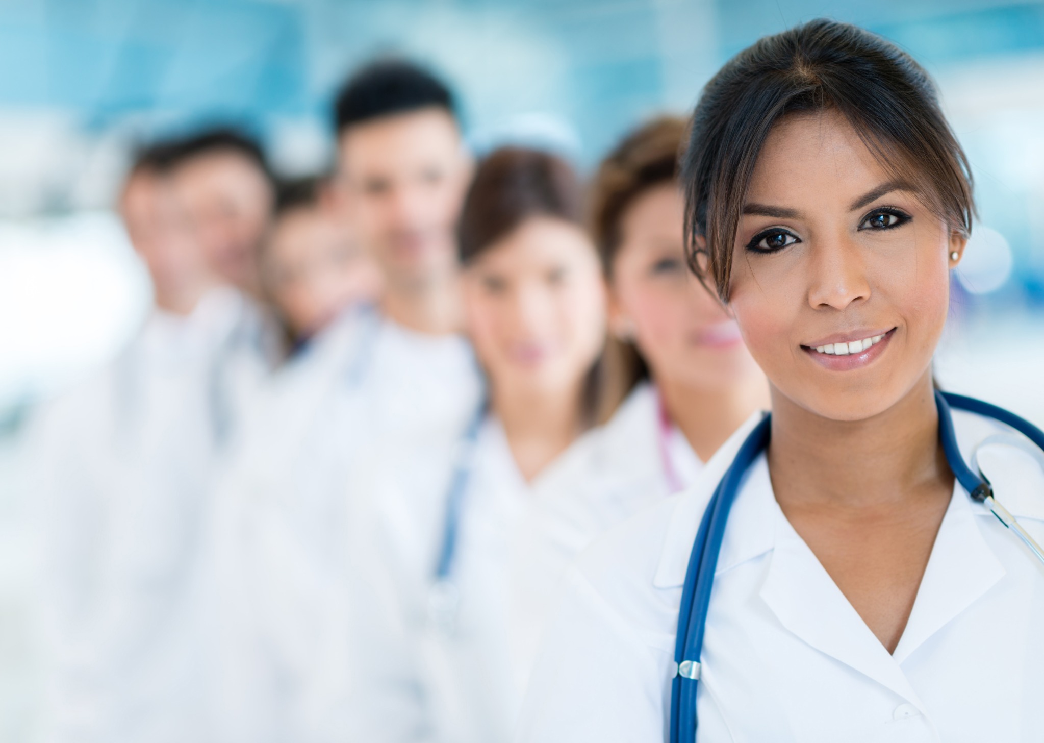 Médica em ambiente clínico com equipe de profissionais da saúde